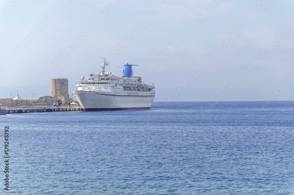 Big white cruise ship docked at marina waiting passengers for luxury vacation