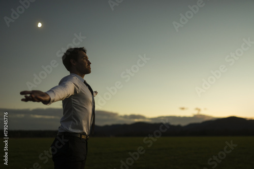 Successful businessman in elegant white shirt with his arms outspread