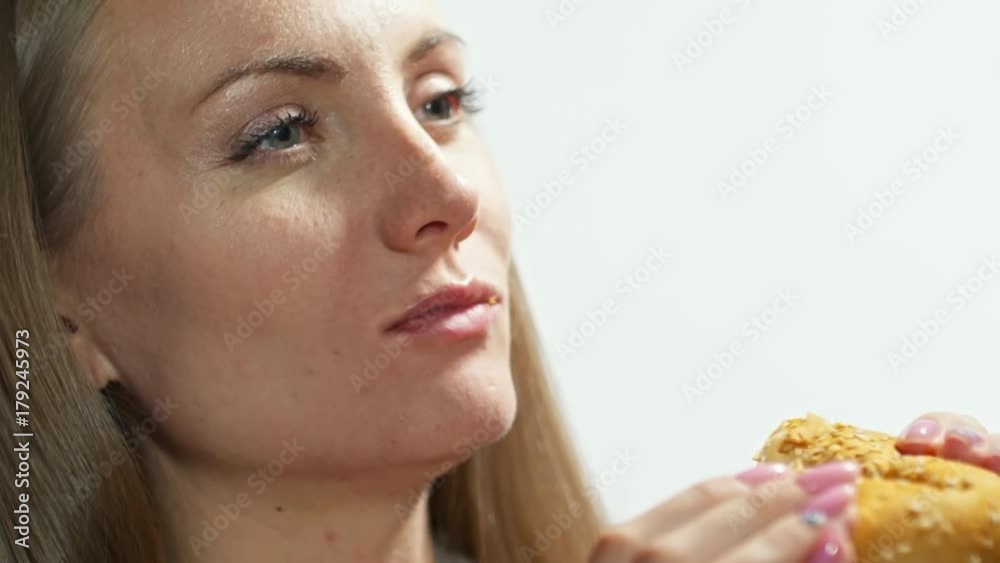 Slowmo of businesswoman enjoying tasty burger with dollar bills Slowmo of businesswoman enjoying tasty burger with dollar bills