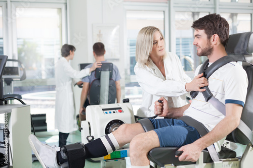 gym physiatric rehabilitation/ physicians with patients in a gym for physical rehabilitation dynamometer in the foreground and in the background cycle ergometer