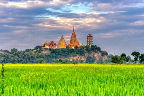 Sunset scence of Wat Tham Sua Temple with rice fields in Kanchanaburi Province, Thailand. photo