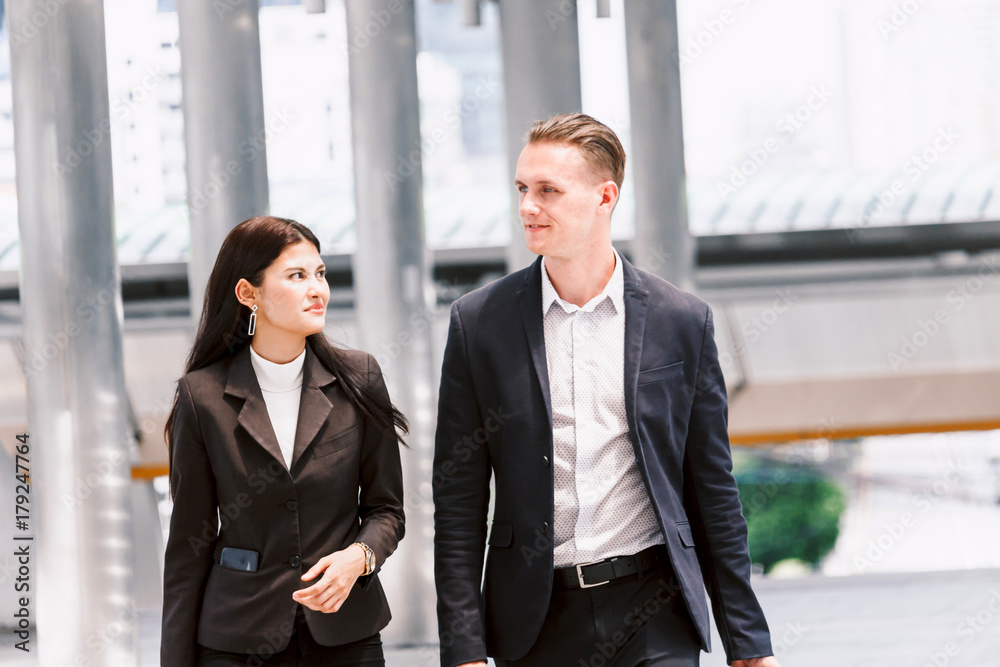 Image two business partners talking and working together Image two business partners talking and working together