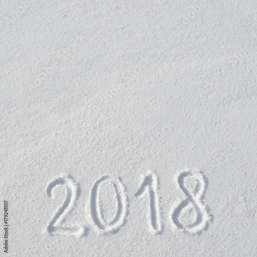 2018 text letters handwritten on flat snow surface. New year holiday seasonal postcard, greeting card template.