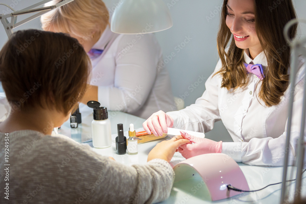 Masters of manicure at work in the beauty salon. Hand care Masters of manicure at work in the beauty salon. Hand care