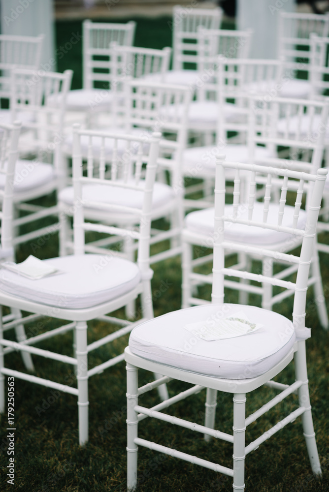 Empty white chairs before wedding ceremony