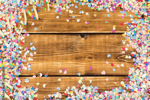 wooden background with confetti and streamer frame