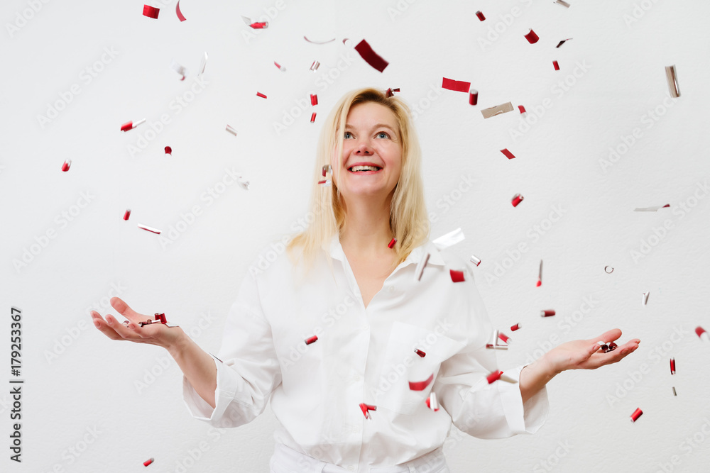 Happy woman at celebration party with confetti falling everywhere on her. Happy woman at celebration party with confetti falling everywhere on her.