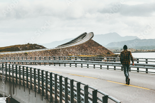 Man running away at Atlantic road in Norway Storseisundet bridge Travel Lifestyle concept adventure vacations outdoor photo