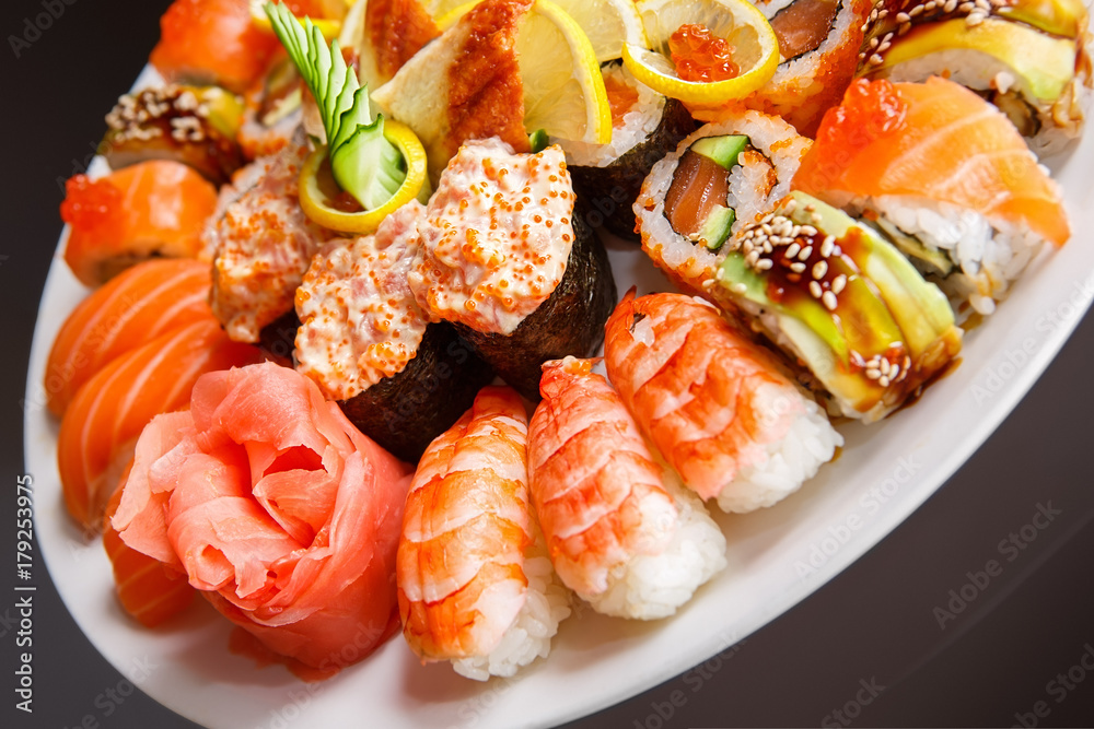 Maki, uramaki and nigiri sushi served in white plate close up Maki, uramaki and nigiri sushi served in white plate close up