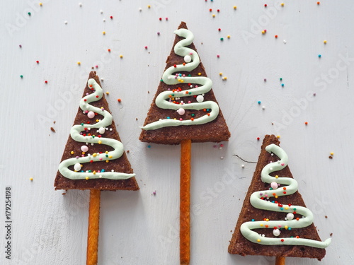 Culinary background with Christmas tree shaped biscuits. Homemade sugar cakes glazed with royal icing. Copy space for your text. Top view.