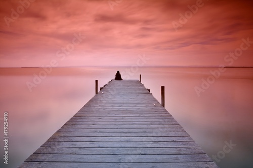 Fototapeta Naklejka Na Ścianę i Meble -  Lonely person sitting on pier