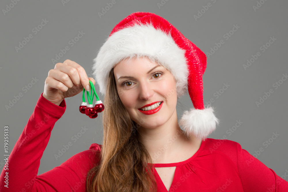 Junge Frau mit Weihnachtsmütze hält Christbaumschumck Junge Frau mit Weihnachtsmütze hält Christbaumschumck