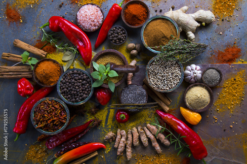 Fototapeta Naklejka Na Ścianę i Meble -  A selection of various colorful spices on a wooden table in bowls