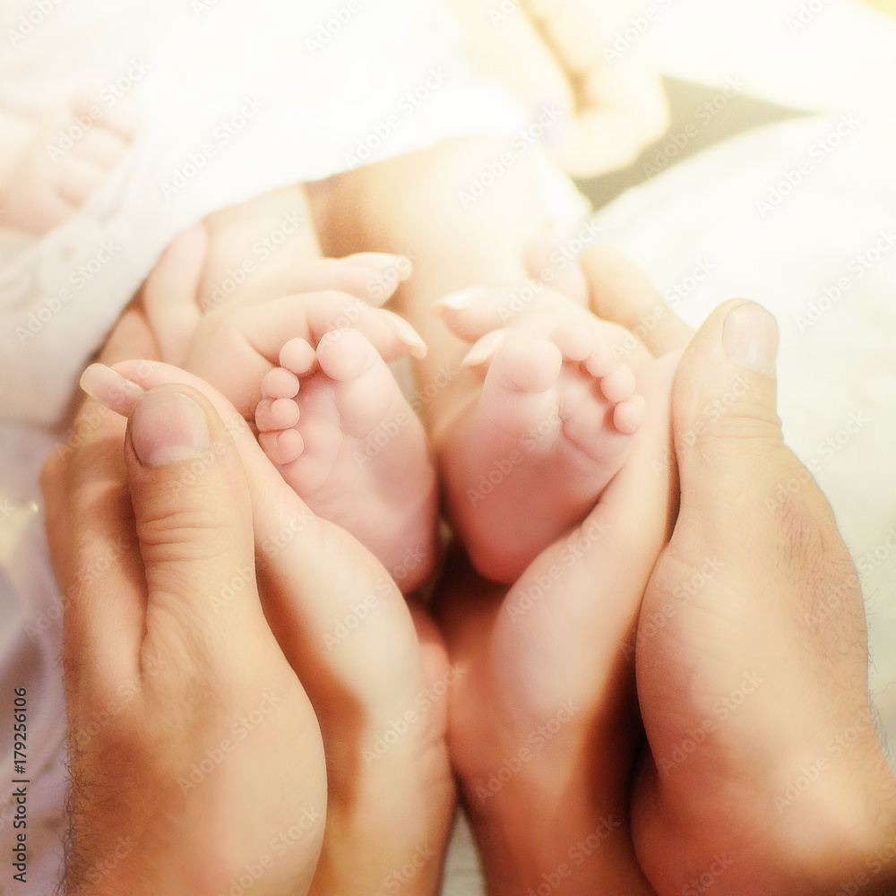 Legs newborn baby hands hug mom and dad, forming a heart. Symbolizes love, unity, caring, tender to the baby Legs newborn baby hands hug mom and dad, forming a heart. Symbolizes love, unity, caring, tender to the baby