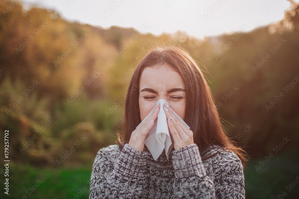 young woman with handkerchief. Sick girl has runny nose. Female model makes a cure for the common cold on an autumn background young woman with handkerchief. Sick girl has runny nose. Female model makes a cure for the common cold on an autumn background
