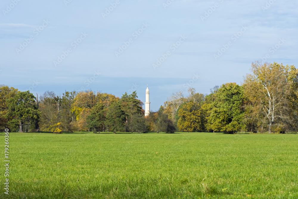 View of Minaret in Lednice between trees under autumn sky View of Minaret in Lednice between trees under autumn sky
