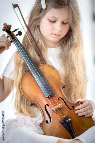 beautiful girl with long hair playing a violin 