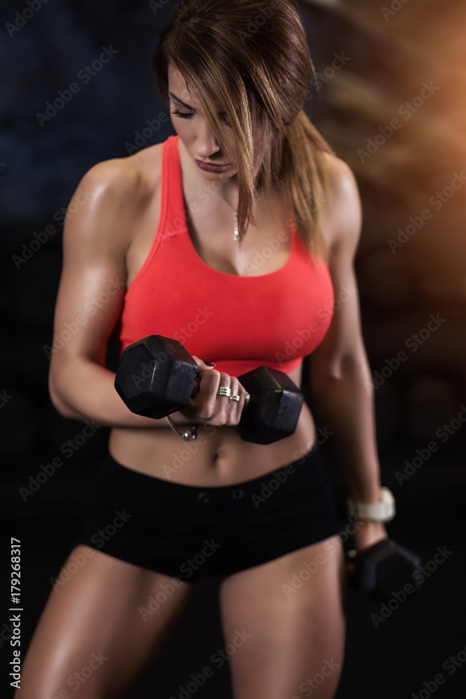 Dziewczyna ćwicząca biceps na siłowni - obrazy, fototapety, plakaty 
