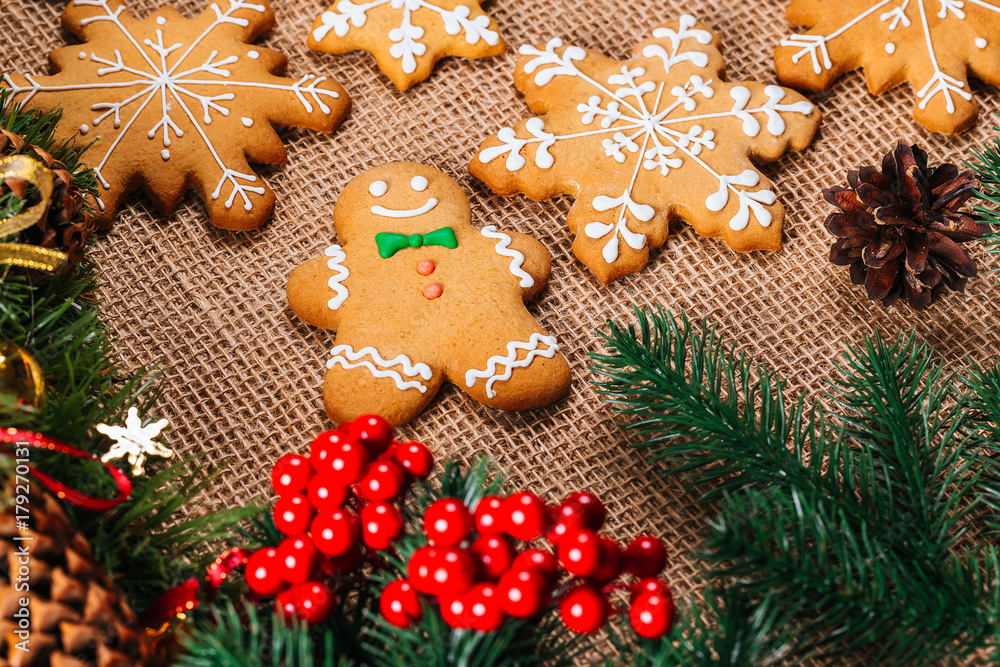 Christmas gingerbread cookies homemade with branches of Christmas tree and New Year decor on table with burlap tablecloth. Merry Christmas postcard. Christmas gingerbread cookies homemade with branches of Christmas tree and New Year decor on table with burlap tablecloth. Merry Christmas postcard.
