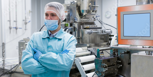 Fotografi widescreen picture, factory worker is standing near machine, steel machines, man