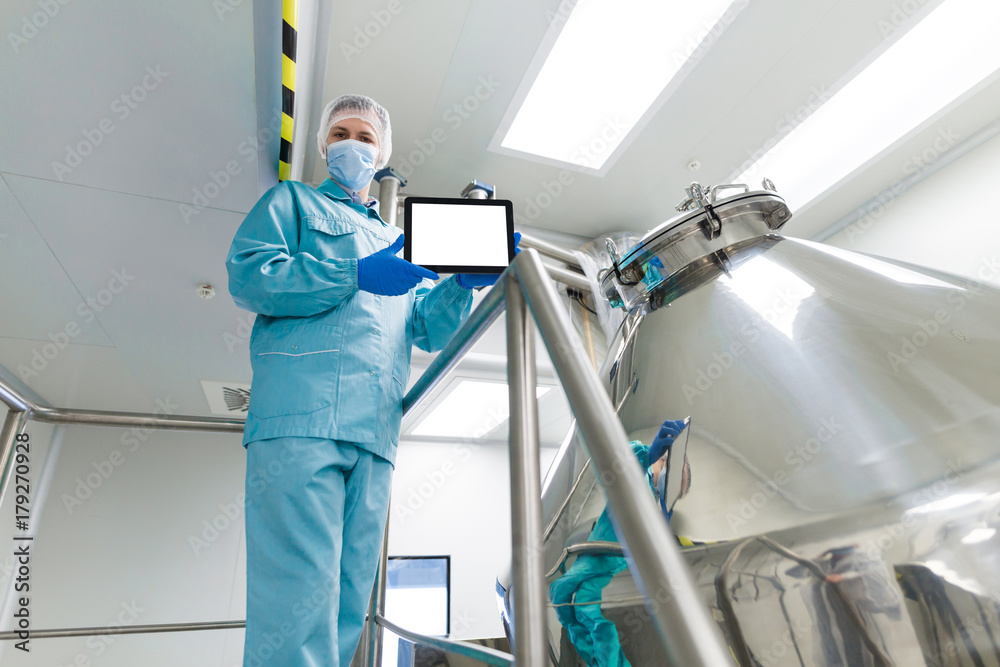 scientist show empty tablet near steel tank scientist show empty tablet near steel tank