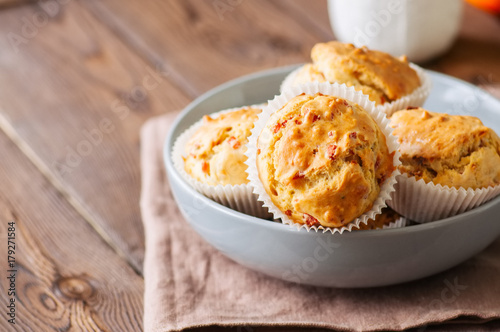 Homemade muffins with bacon and cheese in a gray plate. Healthy snack or breakfast meal. Wooden background.