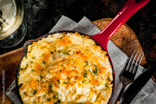 Skillet Shepherd's Pie, british casserole in cast iron pan, with minced meat, mashed potatoes and vegetables, on dark rusty background, copy space top view photo