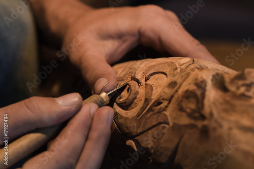 close up picture of woodcarver at work, handcrafting with wood  