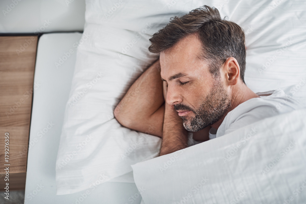 Man sleeping peacefully in bed - obrazy, fototapety, plakaty 