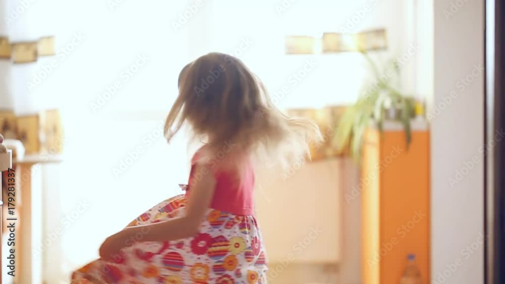 Little girl is spinning around inside the house