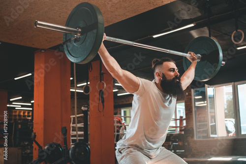 Gym. Bearded man training.