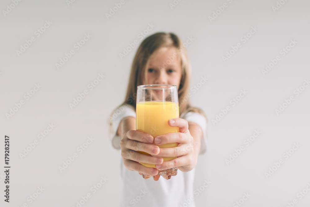 Happy girl holding glass of orange juice isolated on white background. Nerd is wearing glasses. Happy girl holding glass of orange juice isolated on white background. Nerd is wearing glasses.