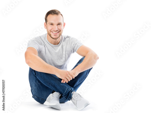 Man sitting with his legs crossed. Smiling guy.