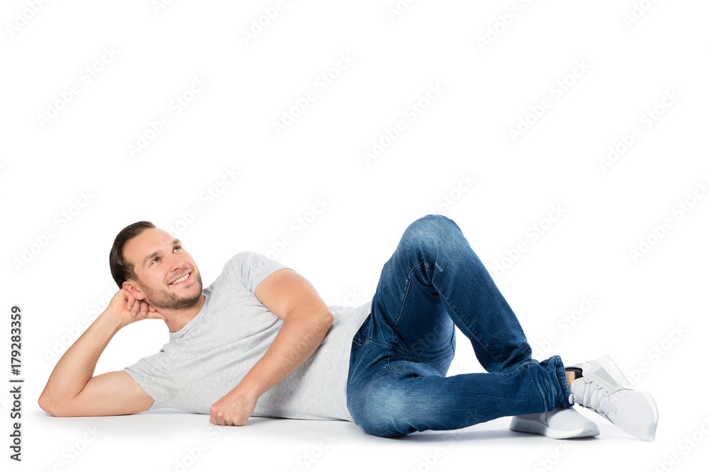 Carfree man laying on the floor, thinking.