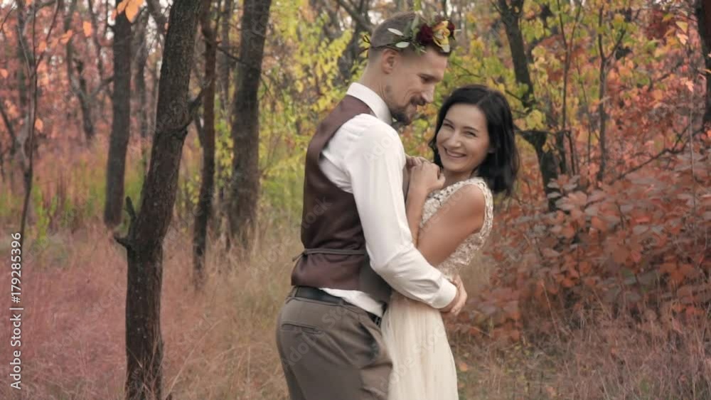 A loving couple having fun and hugging in an autumn park, slow motion A loving couple having fun and hugging in an autumn park, slow motion