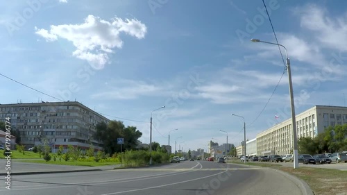 The traffic of cars on the city road, timelaps. Blue sky with white clouds.