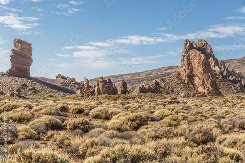 Orange rocks in the middle of an arid landscape with a bit of vegetation