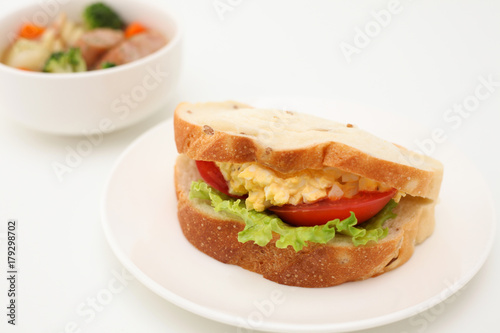 お皿にのせた エッグレタストマトサンド パン サンドウィッチ  ポトフ スープ 白背景
