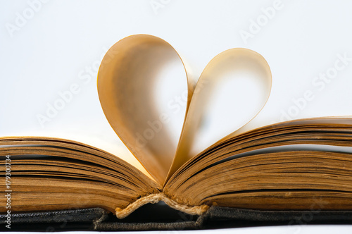 Heart shaped old book pages isolated on white.