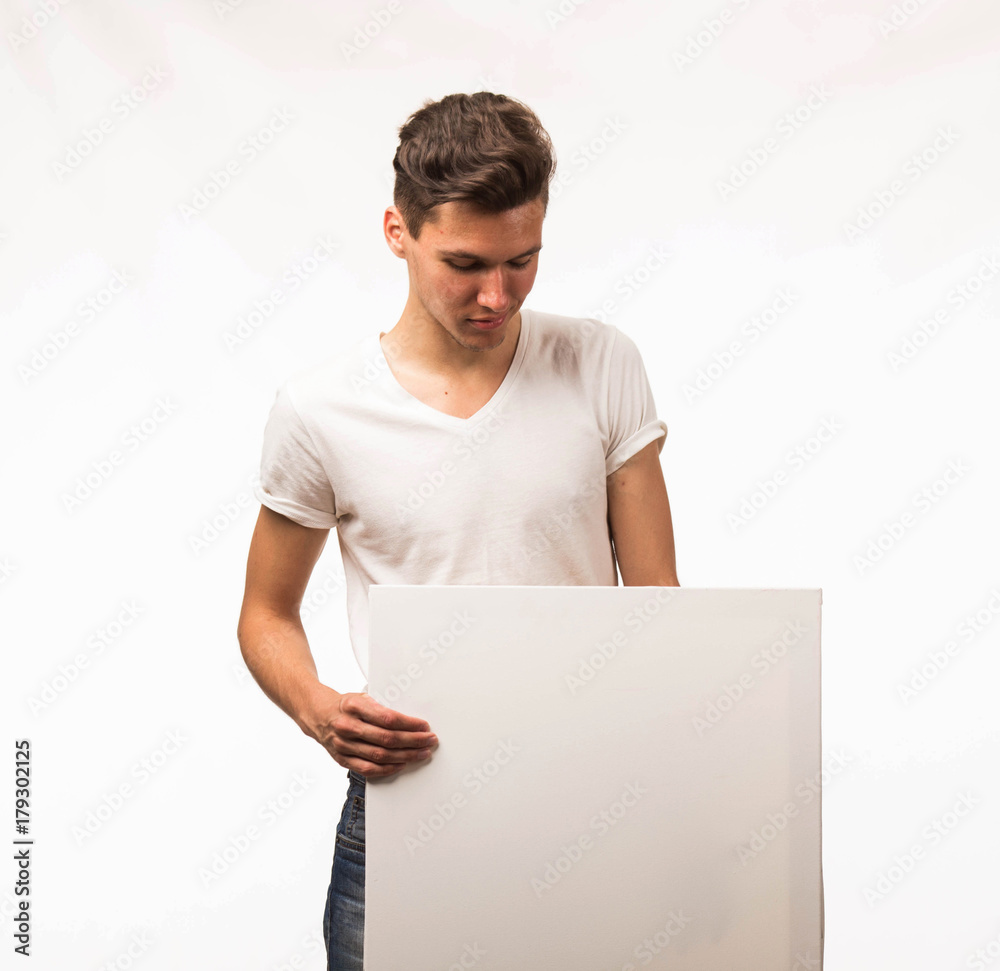Young wistful man portrait of a confident businessman showing presentation, pointing paper placard gray background. Ideal for banners, registration forms, presentation, landings, presenting concept. Young wistful man portrait of a confident businessman showing presentation, pointing paper placard gray background. Ideal for banners, registration forms, presentation, landings, presenting concept.