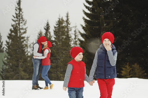 Mother, father and two sons having fun in snow winter