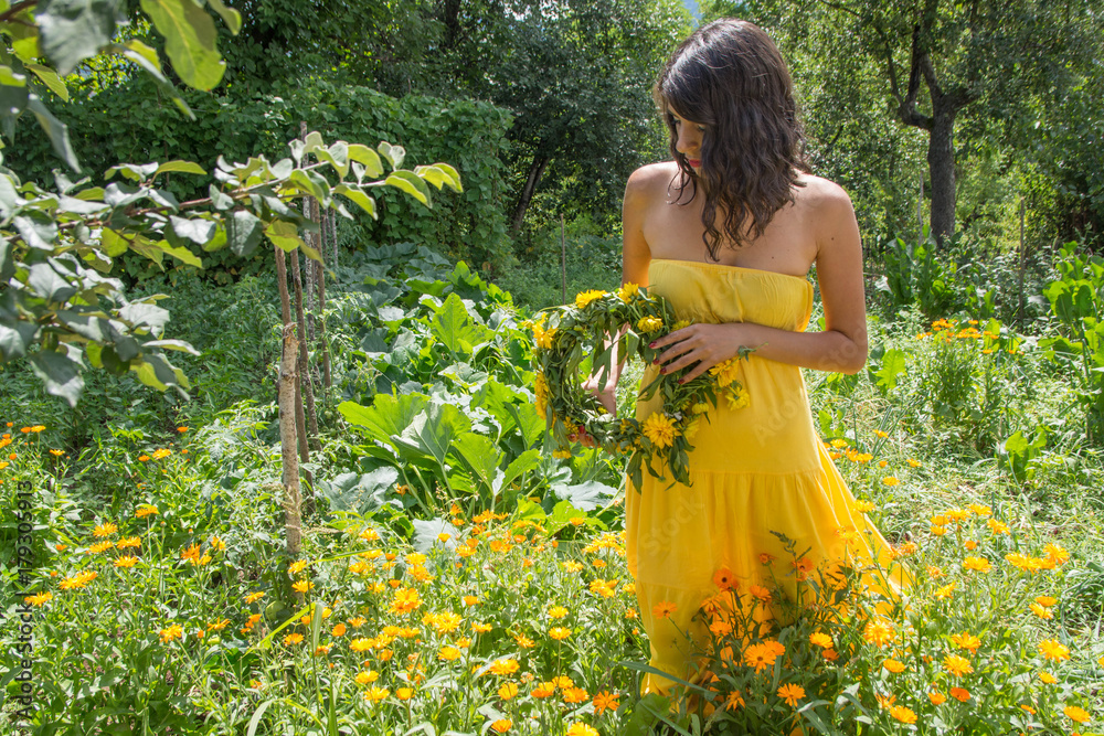 Dreamy young woman in yellow dress with wreath made of yellow flovers Dreamy young woman in yellow dress with wreath made of yellow flovers
