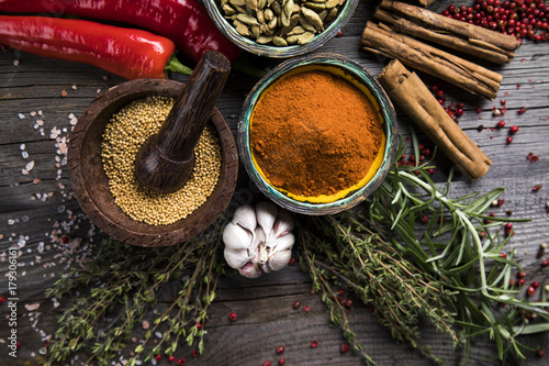 Herbs and spices on a wooden bowl background 