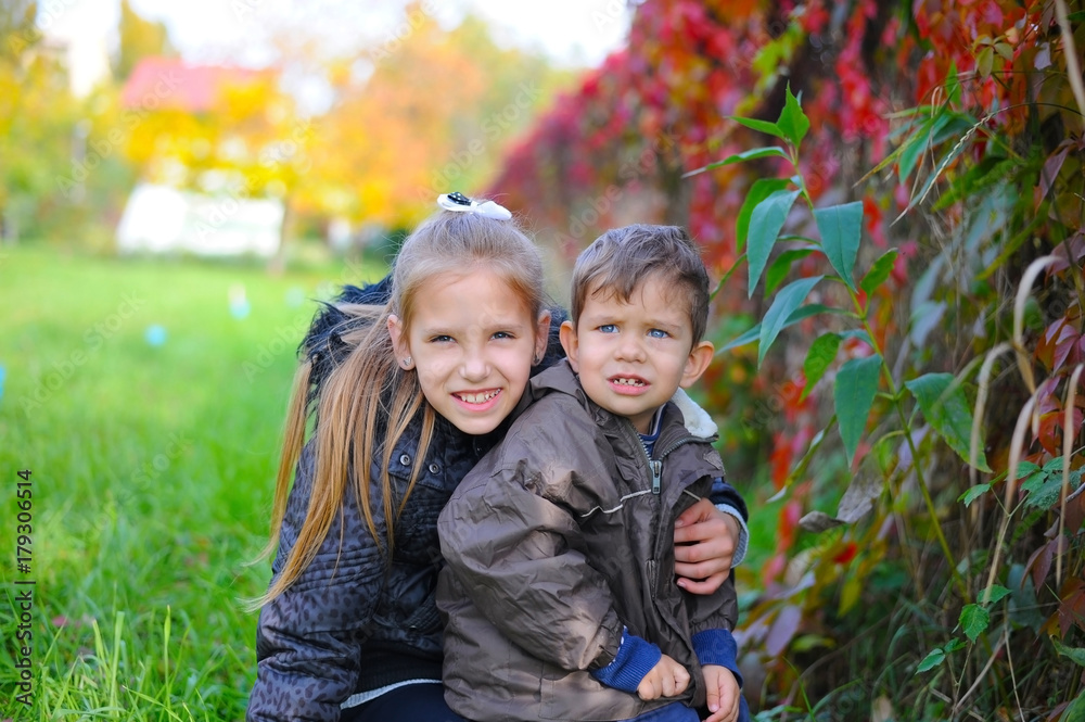 Sister and brother are walking in the autumn park Sister and brother are walking in the autumn park