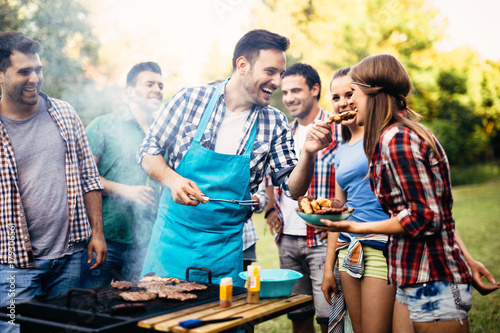 Happy friends enjoying barbecue party photo