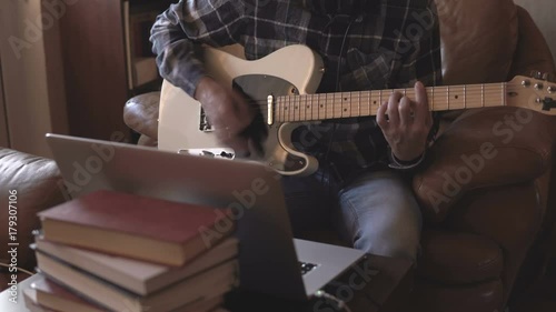 Home recording musician series. A young guy improvising on the guitar