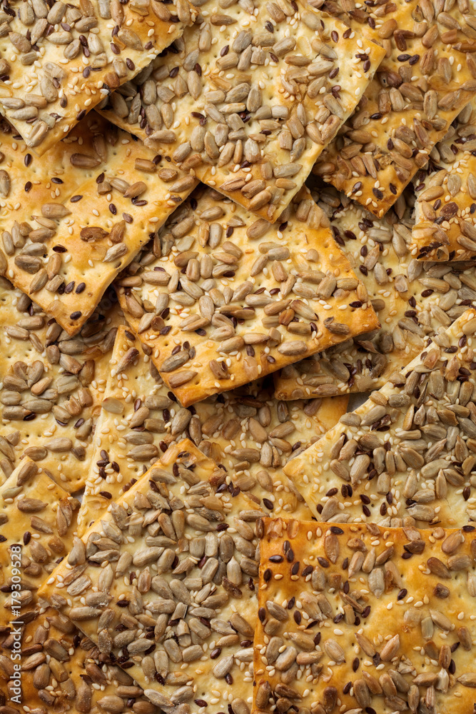 Abstract background of useful bread with sunflower seeds, flax and sesame seeds. Selective focus. Top view.