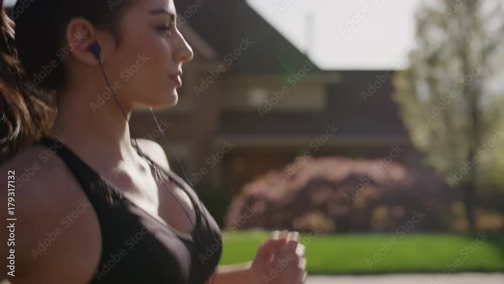 Close up slow motion tracking shot of woman running in neighborhood / Cedar Hills, Utah, United States