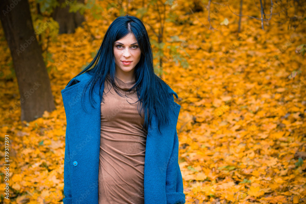 Portrait of young beautiful woman in autumn blue oversized coat. Brunette fashion woman walking outdoor against an autumn nature landscape High fashion photo of elegant woman stylish in boho style Portrait of young beautiful woman in autumn blue oversized coat. Brunette fashion woman walking outdoor against an autumn nature landscape High fashion photo of elegant woman stylish in boho style