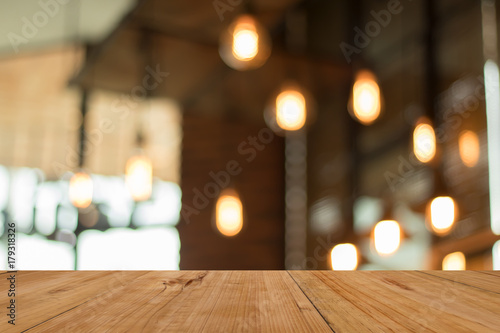 Wood board empty table in front of blurred coffee shop lamp background. for display or montage your product. mock up for display of product